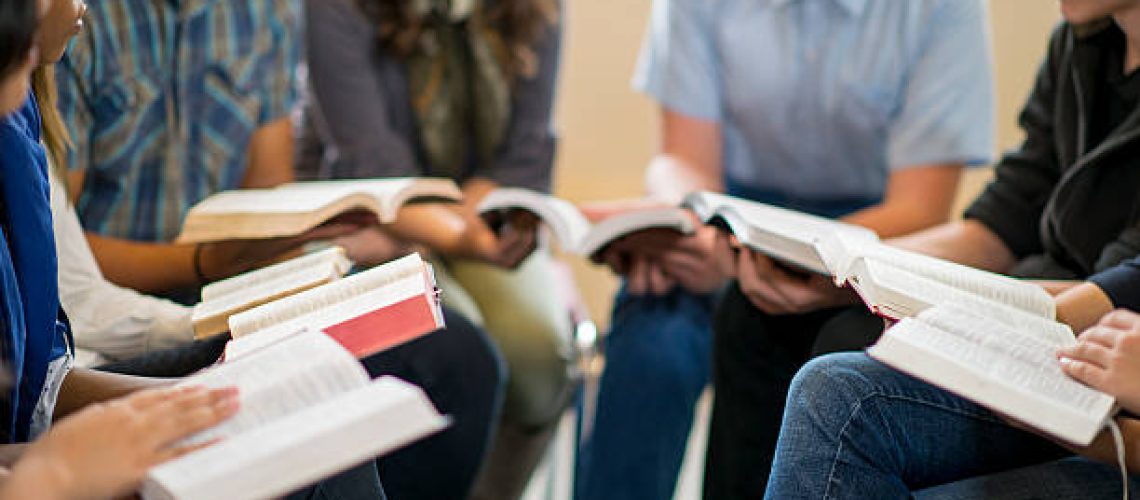 Diverse group of teens studying the Bible.